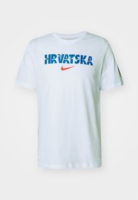 Hvid bomulds t-shirt med "HRVATSKA" i blå og et rødt Nike-logo. Korte ærmer og normal pasform. Enkel design uden mønstre.