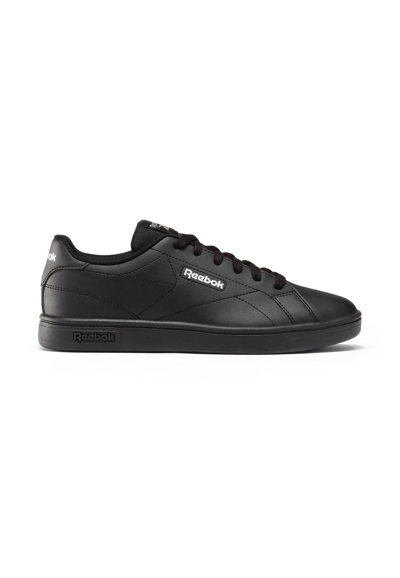 Zapatillas Reebok negras con una parte superior de cuero suave, punta redonda, acentos texturizados y cordones planos negros, con un logo en el lateral y en la lengüeta.