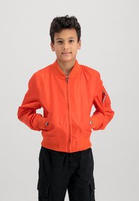 Orange bomber jacket made of smooth fabric, featuring a zip closure, ribbed cuffs, and two side pockets, one adorned with a zipper pocket.