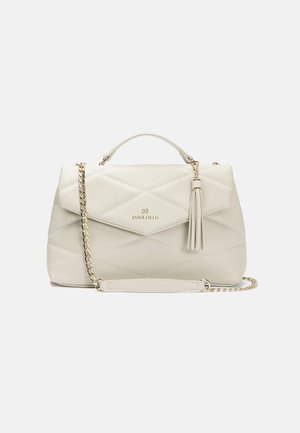Sac à main en tissu matelassé beige clair avec une poignée supérieure, une bandoulière en chaîne détachable, un logo doré et un détail de frange sur le rabat.