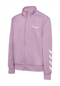 Lyse lilla jakke med lynlås, der har en stående krave, hvidt logo og kontrasterende hvide chevron-striber på ærmerne. Blød stoftekstur.
