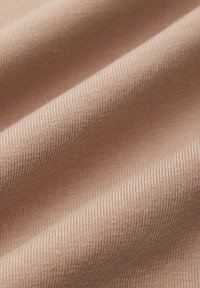 Beżowa tkanina w prążki o gładkiej fakturze, ukazująca widoczne cienkie poziome linie oraz delikatne fałdy, tworzące głębię i ruch.