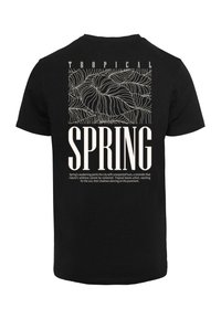 Sort bomulds t-shirt med et hvidt grafikdesign med tropiske bladmønstre og fedt "SPRING" tekst på ryggen.
