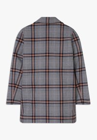 Chaqueta a rayas de manga larga en gris, azul marino, blanco y marrón con un cuello ajustado, vista desde la parte posterior sobre un fondo blanco.