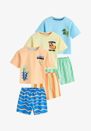 Drei bunte Kleinkind-Outfits mit kurzärmeligen Oberteilen mit sommerlichen Drucken und passenden gestreiften oder wellenförmigen Shorts.