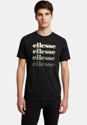 Jeune homme portant un t-shirt noir avec le mot "ellesse" imprimé quatre fois en dégradé vertical du blanc au gris foncé.