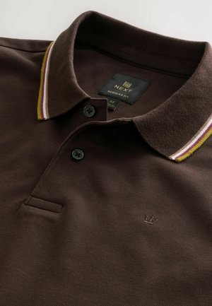 Brun polo skjorte med et struktureret stof, der har en ribbet krave i gul, maroon og hvide striber, samt tre sorte knapper.