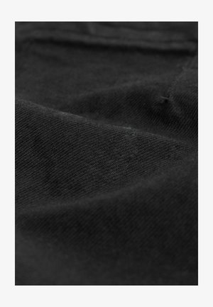 Crni materijal s mekim, teksturiranim završetkom, s suptilnim varijacijama u tkanju, što stvara glatki, mat izgled.