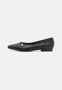 Bailarinas de cuero negro con punta afilada, con un pequeño acento de perla y un tacón cuadrado y plano. Textura suave en toda la superficie.