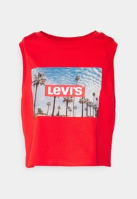 T-shirt rouge sans manches et court en coton, avec une impression photo de palmiers sous un ciel bleu et un logo blanc Levi's.