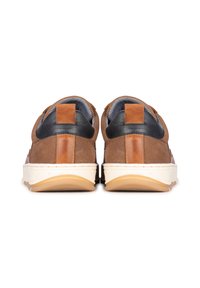 Zapatillas deportivas de ante marrón con detalles en cuero negro y una suela de goma de color crema claro. Presentan un acabado texturizado y una lengüeta del talón en contraste.