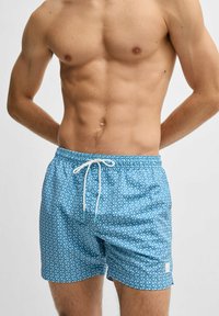 Blå rutiga badshorts med resårmidja, vit snörning och en logotyp på den nedre sidan. Lättviktigt, snabbtorkande tyg.