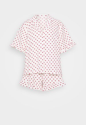 Balta pidžamu komplekts, kas sastāv no īsām piedurknēm un šortiem, rotāts ar maziem sarkaniem sirds rakstiem un viļņotiem malām.