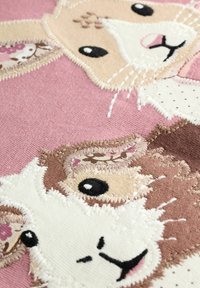 Bestickter Stoff mit zwei Tiergesichtern: einem hellbraunen Hasen und einer dunkelbraunen Ziege auf einem rosa Hintergrund. Detaillierte Stiche und Texturen.