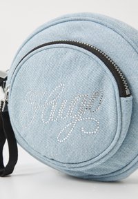 Gaiši zila džinsa apļa soma ar melnu rāvējslēdzēju, priekšpusē ar rhinestone akmentiņiem izrotāts "Hug" dizains. Iekļauta regulējama melna siksna.