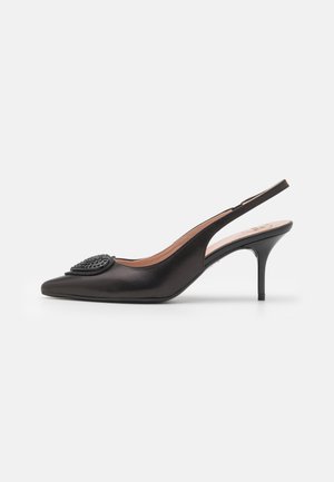Zwart leren slingback kitten heel met puntige neus en decoratief getextureerd cirkelvormig detail bovenop.