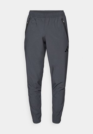 Pantaloni sportivi grigi con cintura elastica, due tasche laterali con zip e dettagli neri. Realizzati in materiale elastico e leggero.