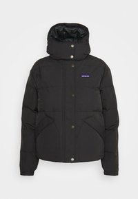 Black puffer jacket with a high collar, snap buttons, and side pockets. Features a slight shine and a small logo on the upper left side.
