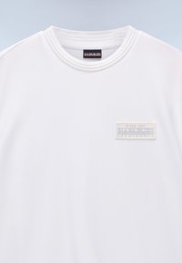 T-shirt bianca a girocollo con collo a coste e una piccola toppa rettangolare sul petto con la scritta "Napapijri Geographic Since 1987".