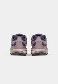 Chaussures de sport violettes avec une tige en maille texturée, un col rembourré et une semelle amortissante dotée d'aérations visibles et d'une semelle extérieure flexible.