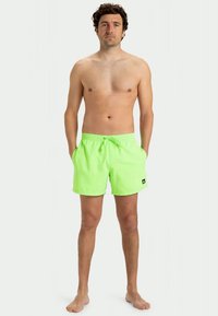 Neon žalios maudymosi šortai su elastinga juosta ir šnurku, su šoninėmis kišenėmis ir mažu logotipo žyme kairėje kojoje.