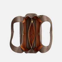 Taupe leather handbag with dual handles, open top showing a central zippered compartment and multiple inner pockets in tan lining.