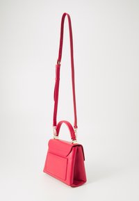 Sac à main en cuir rose avec une forme structurée, doté d'une poignée supérieure et d'une sangle ajustable. Quincaillerie dorée et détail de poche avant.