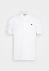Polo shirt blanc en coton avec un col classique, une patte de boutonnage à deux boutons et un petit logo Lacoste bleu sur la poitrine gauche.