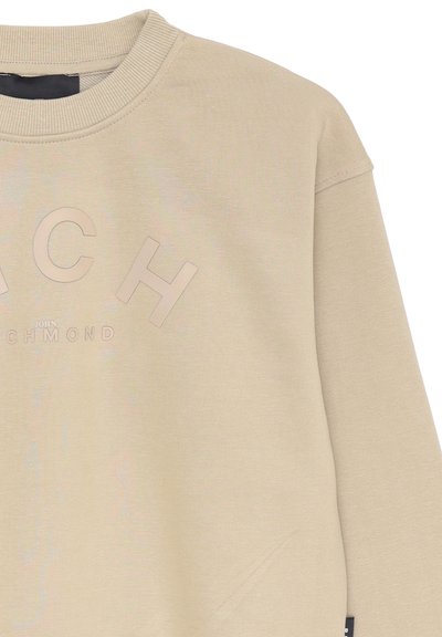 Felpa beige con testo in rilievo "RICH JOHN", colletto a costine e tessuto leggermente strutturato. Include un dettaglio con etichetta laterale.