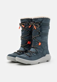 Modré zateplené zimní boty s nadýchanou bílou podšívkou, barevnými splétanými tkaničkami a texturovanou gumovou podrážkou pro lepší trakci.