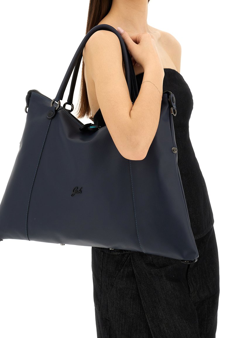 Borsa tote in pelle blu navy con finitura opaca, cuciture ben evidenti e dettagli in argento. Dotata di doppie spalline e chiusura con zip.