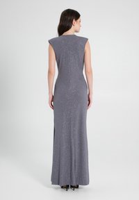 Lang, tailliertes graues Kleid mit einem subtilen Glitzern, kurzen Ärmeln und einer geraden Silhouette. Verfügt über eine mittige Rückennaht und einen seitlichen Schlitz.