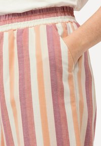 Raidat housut, joissa on kiristysnauha pehmeässä kankaassa. Värit sisältävät persikan, kerman ja burgundin. Ominaisuuksiin kuuluvat sivutaskut ja herringbone-kuvio.