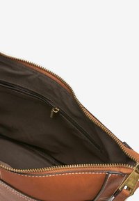 Braune Ledertasche mit gefüttertem Innenraum. Verfügt über einen Reißverschluss, eine zusätzliche Reißverschlusstasche und kontrastierende Nähte. Glatte Textur.
