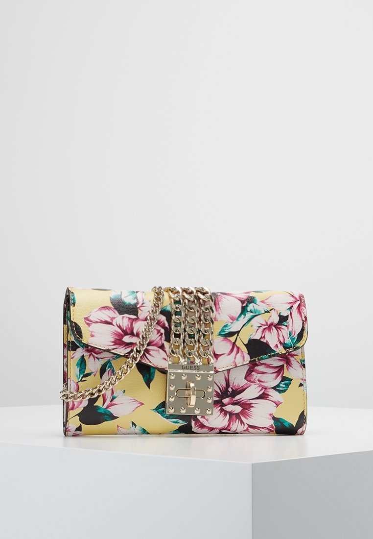 Blomster crossbody taske med gul baggrund, prydet med pink blomster. Guld hardware og en kædestrop komplimenterer dens rektangulære design.