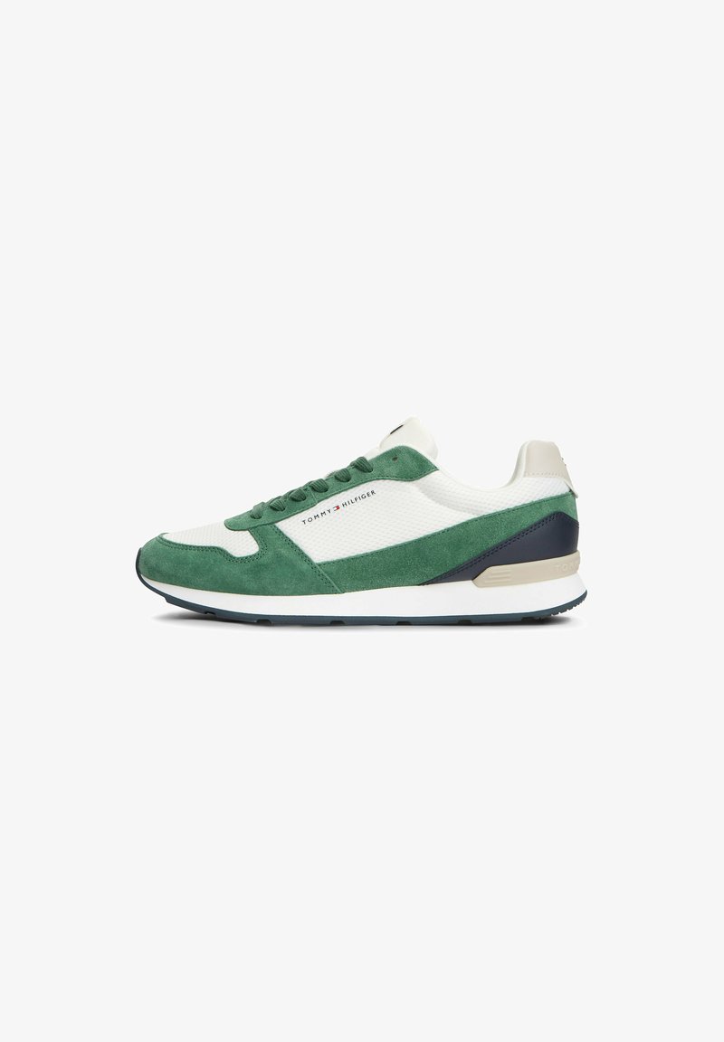 Baskets basses en daim vert, panneaux en mesh blanc, talon bleu marine, semelle blanche et logo Tommy Hilfiger sur le côté.