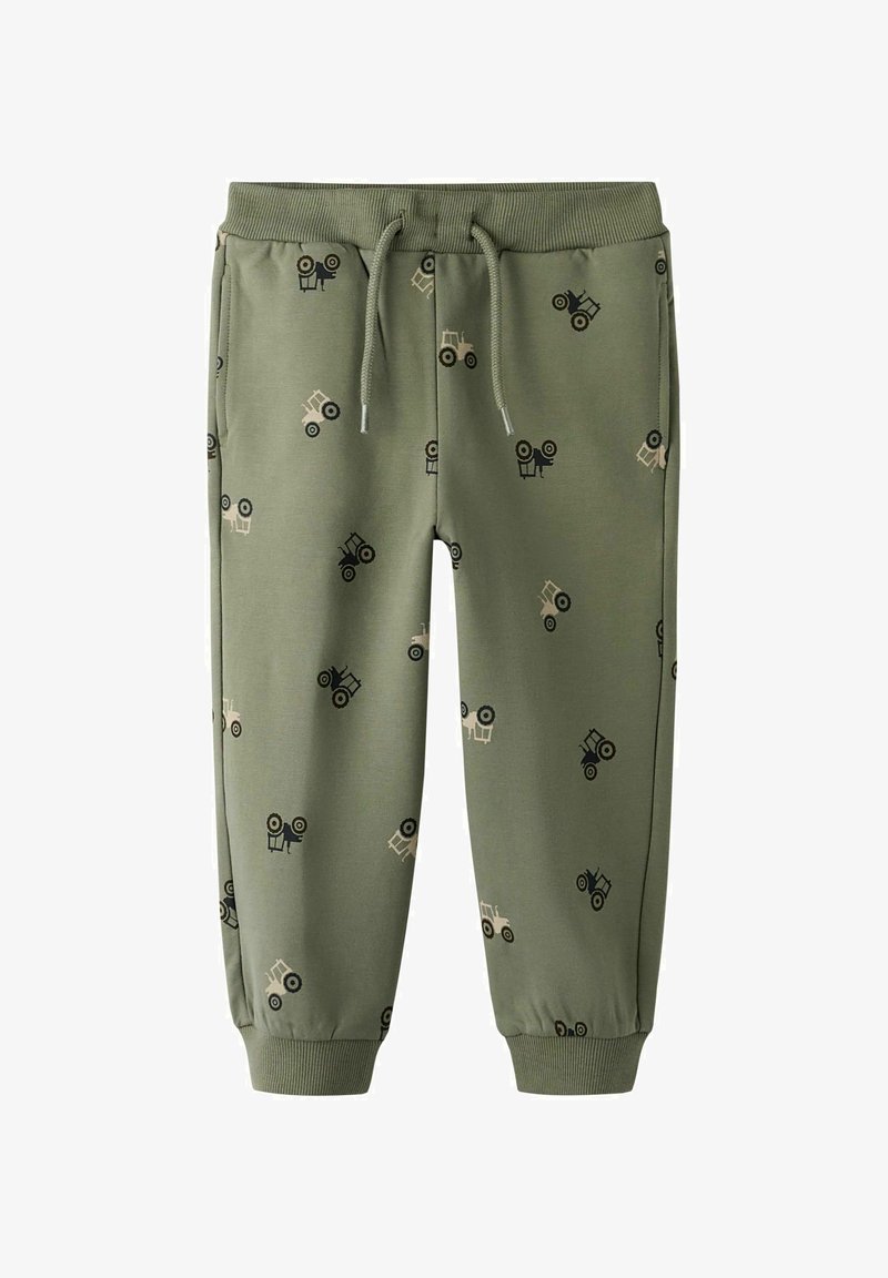 Zelene trenirke z elastičnim pasom in vrvico. Okrašene s majhnimi traktorji v črni in bež barvi. Z obrobami na gležnjih.