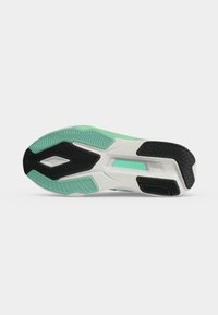 Εξωτερική σόλα αθλητικού παπουτσιού New Balance με μαύρα και μέντα πράσινα σχέδια σε λευκή βάση.