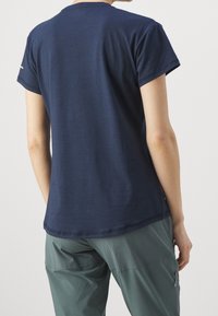 Tmavě modré bavlněné tričko s krátkými rukávy, kulatým výstřihem a hladkou texturou. Jednoduchý design bez vzorů nebo zdobení.