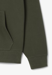 Felpa con cappuccio verde scuro in tessuto strutturato, con tasca a marsupio e polsini a coste. Finitura liscia e design aderente.