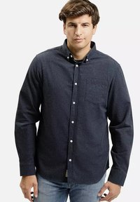 Granatowa, długosleeve, koszula zapinana na guziki z kieszonką na piersi, bawełniany materiał i białe guziki, noszona z jasnoniebieskimi dżinsami.