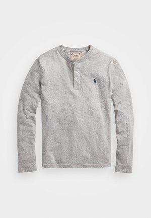 Pilkas ilgarankovis henley marškinis, pagamintas iš minkštos medžiagos, su trimis mygtukais ir mažuoju mėlynu siuvinėtų emblemų ant krūtinės.