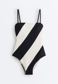Eendelig badpak met brede diagonale zwart-witte strepen en dunne zwarte schouderbandjes, plat uitgespreid op een witte achtergrond.