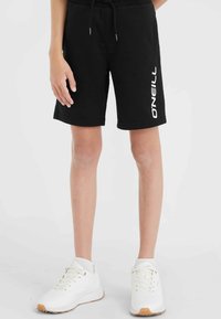 Svart bomullsshorts med O'Neill-logotyp i vitt tryckt på sidan. Shortsen har ett elastiskt midjeband och sidofickor.