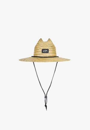 Cappello di paglia con ampia tesa, di colore beige chiaro, con una toppa in tessuto nero con logo, e una fascia regolabile nera per il mento.