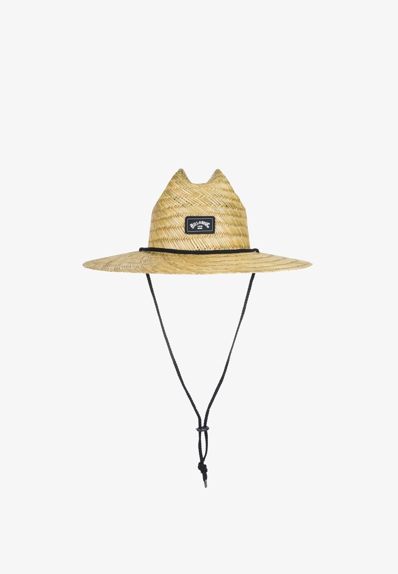 Strohhut mit breiter Krempe, in hellbrauner Farbe, ausgestattet mit einem schwarzen Stoffpatch mit Logo und einem verstellbaren schwarzen Kinnriemen.