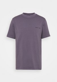 T-shirt violet à manches courtes avec un col rond, portant un petit logo en texte noir "SAMSOE SAMSOE" sur la poitrine gauche.