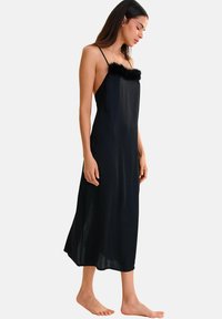 Robe de soirée en satin noir avec des bretelles spaghetti réglables, comportant un doux col en fausse fourrure et une silhouette évasée fluide.