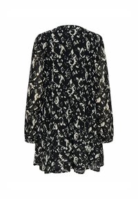 Robe noire avec un motif abstrait blanc, manches longues, design en niveaux, fabriquée à partir d'un tissu léger. Vue arrière affichée.