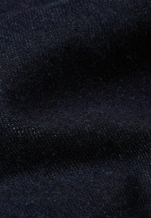 Primer plano de tela texturizada azul oscuro con patrón de tejido visible y suaves pliegues.